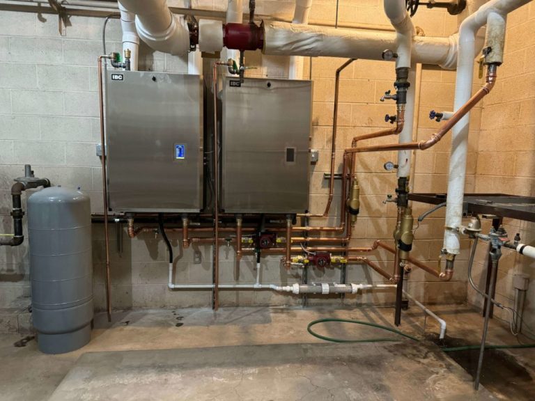 Two new high-efficiency boilers with copper piping after a church boiler replacement