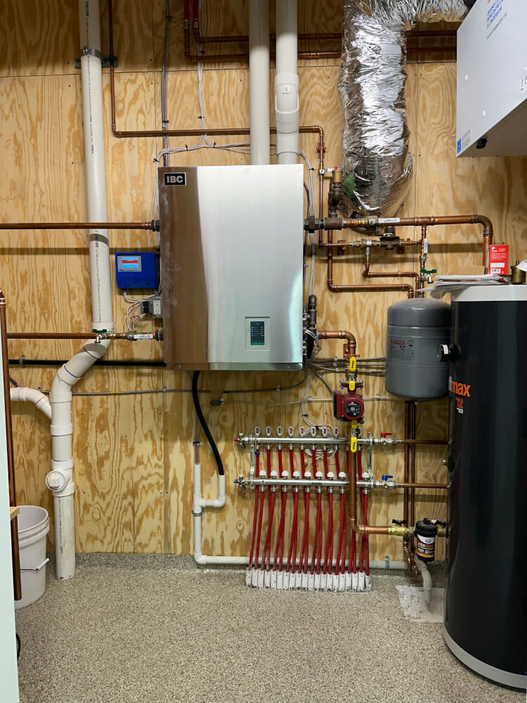 Wall-hung boiler and radiant heat manifold in a Rice Lake new construction home