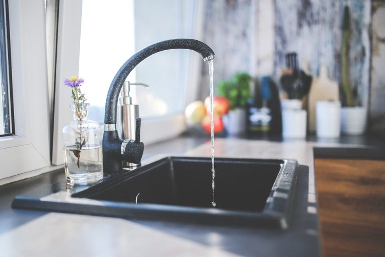 Kitchen faucet running water into a sink
